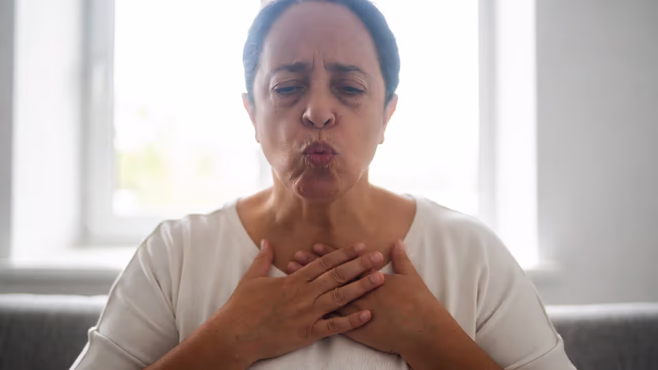 Adult practicing extended exhale breathing with hands on chest and belly