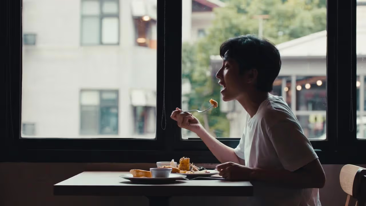 Traveler eating meal attentively at local restaurant.
